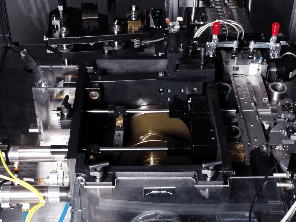 Close-up of a custom assembly station with a black tooling plate, toggle clamps and air lines
