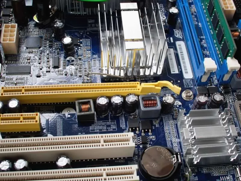 Computer motherboard with expansion slots, capacitors and a heat sink