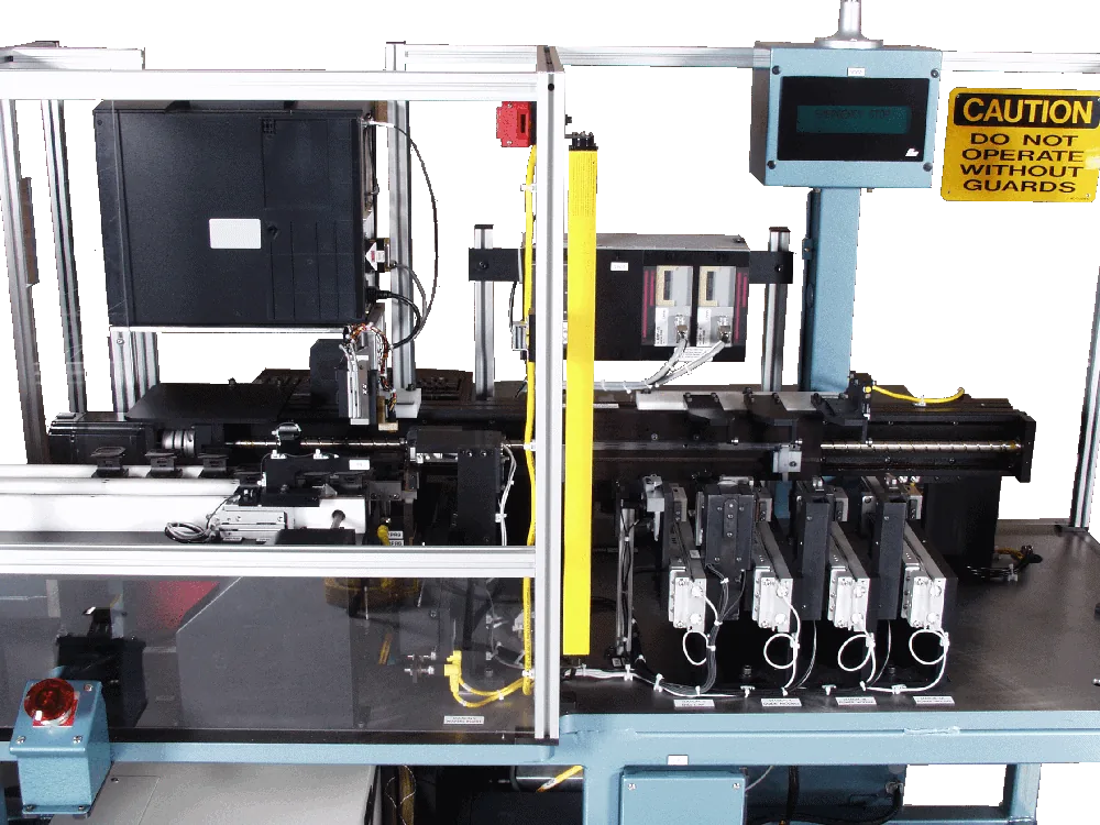 Close-up of a connector assembly machine with a caution sign and servo drives