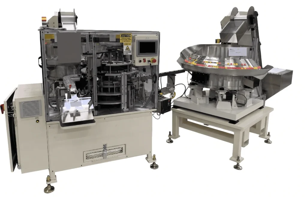Continuous motion machine next to a bowl feeder on a stand