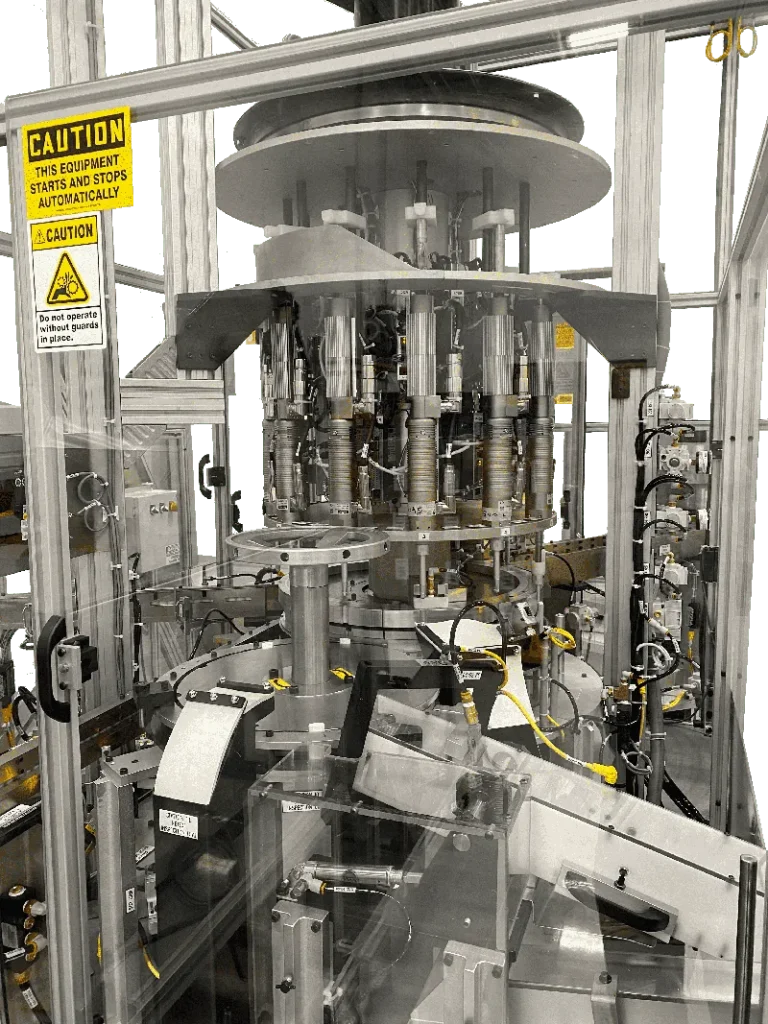 Continuous motion machine with a rotary turret and warning labels